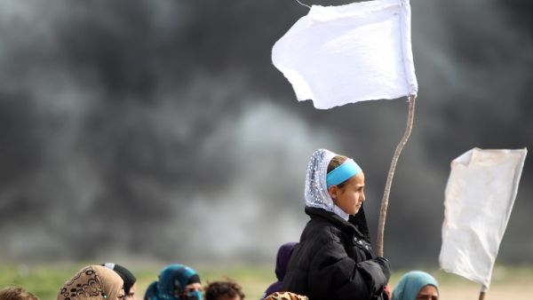 Iraqi girls hold makeshift white flags as they flee with their families a military operation by Iraqi security personnel aimed at retaking areas from Daesh, in the desert west of the city of Samarra on March 3, 2016. (AFP/Ahmad al-Rubaye)