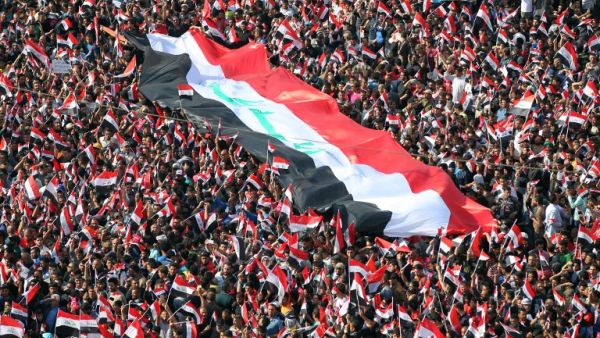 Supporters of Iraqi Shia cleric Moqtada al-Sadr wave national flags during a demonstration calling for governmental reform and elimination of corruption on March 11, 2016, in Baghdad's Tahrir Square. (AFP/Ahmad al-Rubaye)