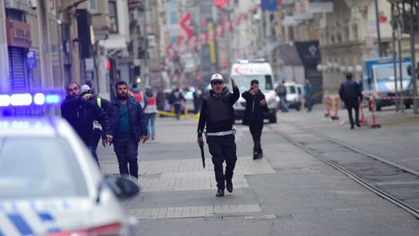 Turkish police push people away just after an explosion on the pedestrian Istiklal avenue in Istanbul on March 19, 2016. (AFP/Bulent Kilic)