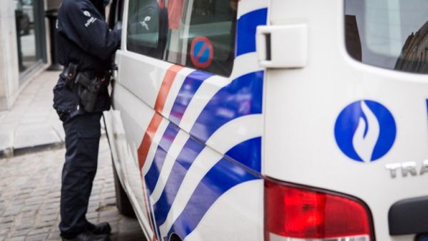 A Belgian police officer stands next to police car outside the Belgian Federal Police headquarters in Brussels on March 19, 2016. (AFP/Aurore Belot)