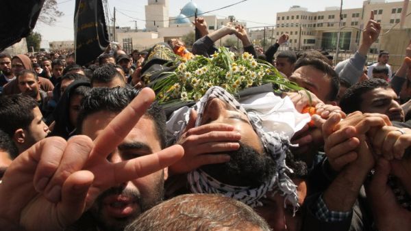 Mourners carry the body of Palestinian Mahmud Abu Fanuna during his funeral on March 19, 2016, in Hebron in the south of the Israeli-occupied West Bank. (AFP/Hazem Bader)