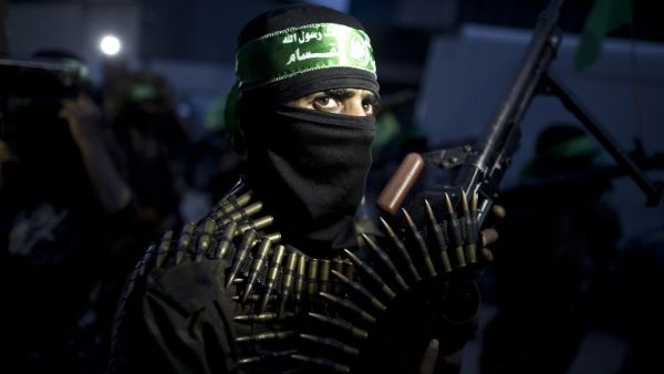 A member of the Ezzedine al-Qassam Brigades, the military wing of the Palestinian Islamist movement Hamas holds his weapon during a rally to mark the 12th anniversary of the death of assassinated Hamas spiritual leader Sheikh Ahmed Yassine on March 23, 2016 outside his home in Gaza city. (AFP/Mahmud Hams)
