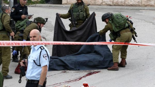 An Israeli soldier was detained after allegedly shooting a wounded Palestinian assailant in the head and killing him as he lay on the ground, with a video of the incident spreading widely online. (AFP/Hazem Bader)