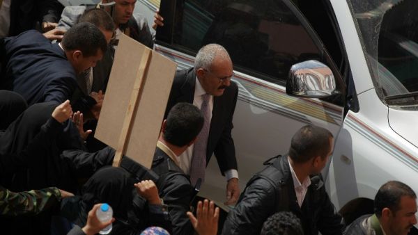 Former Yemeni president Ali Abdullah Saleh is surrounded by his security personnel during a demonstration against the Saudi-led coalition, commemorating one year of the alliance's military campaign against insurgents on March 26, 2016 next to the Monument to the Unknown Soldier in the Yemeni capital Sanaa. (AFP/Muhammad Huwais)