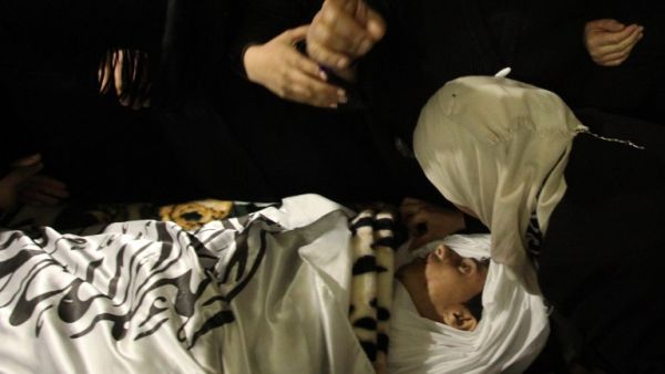 Relatives mourn next the body of Ramzi al-Qasrawi, 21, a Palestinian man who was killed in a reported stabbing attack, during his funeral in the West Bank town of Hebron on March 26, 2016. (AFP/Hazem Bader)
