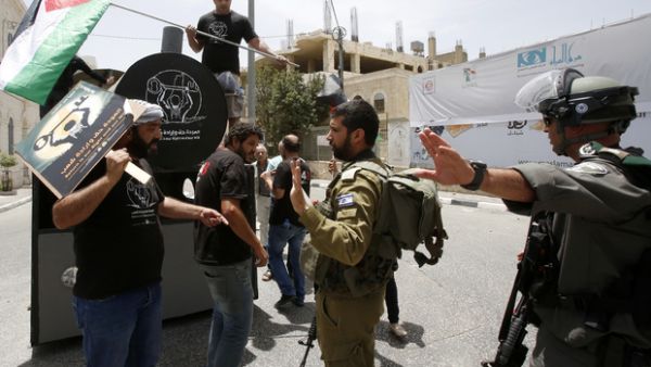 Israeli soldiers and Palestinians confront one another during a symbolic protest to mark Nakba Day (AFP/File Photo)