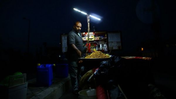 A street vendor during a power cut in Gaza (AFP/File)