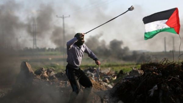 Palestinian protesters hurls a rock at Israeli security forces during clashes near the Shejaiya area of Gaza City along the border with Israel on December 18, 2015. (AFP/Mahmud Hams)
