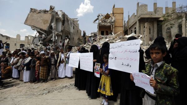 Yemenis stand in protest amidst the debris of a house, hit in an air strike on a residential district, in the capital Sanaa on August 26, 2017. Children were among at least 14 people killed in an air strike that toppled residential blocks in Yemen's capital Sanaa on Friday, witnesses and medics said. (AFP)