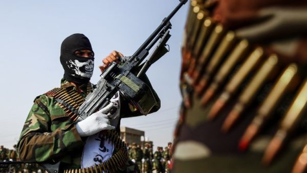 A picture taken on September 16, 2017 shows masked members of the Imam Ali Division, one of the groups fighting within the Hashed al-Shaabi (Popular Mobilisation) paramilitaries, marching with machine guns in a military parade in the holy shrine city of Najaf in central Iraq. 
(Haidar HAMDANI / AFP)