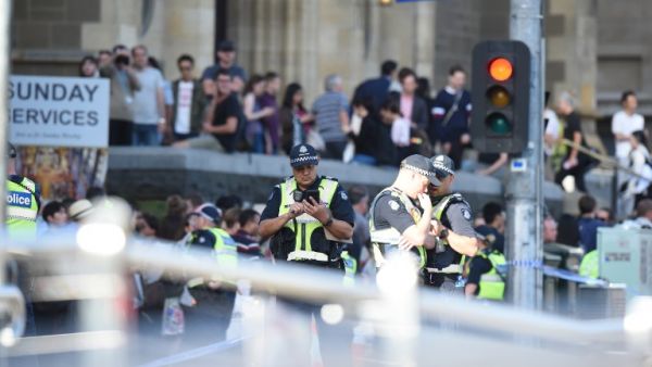 Police and emergency personnel work at the scene of where a car ran over pedestrians in Flinders Street in Melbourne on Dec. 21, 2017 (Mal Fairclough / AFP)