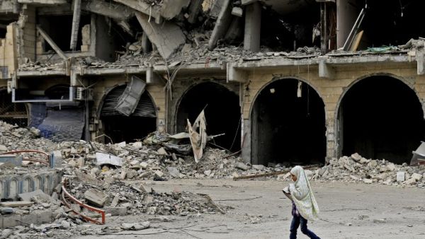 A Syrian girl walks along a destroyed street in Raqa on Dec. 20, 2017, two months after YPG-led Syrian Democratic Forces captured the city from ISIS (Delil souleiman / AFP)