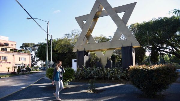 A woman walks across Israel square in Guatemala City (AFP/File Photo)