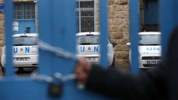 A Palestinian man holds a lock placed symbolically in protest around the main gate of the UNRWA office in the Israeli occupied West Bank city of Hebron on Jan. 17, 2018, after the White House froze tens of millions of dollars in contributions (HAZEM BADER / AFP)