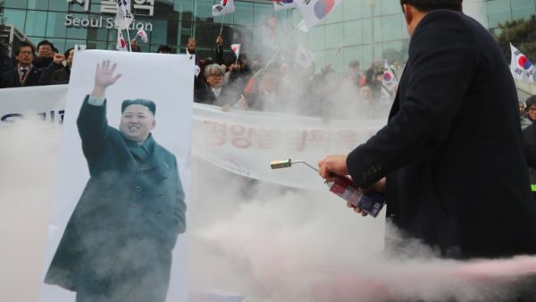 South Korean protesters try to burn a picture of North Korean leader Kim Jong-Un during an anti-North Korea rally outside Seoul station in Seoul on January 22, 2018 as a North Korean delegation arrives at the station (YONHAP / AFP)