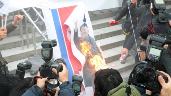 South Korean protesters burn a picture of North Korean leader Kim Jong-Un during an anti-North Korea rally outside Seoul station in Seoul on Jan. 22, 2018, as a North Korean delegation arrives at the station (Dong-A Ilbo / AFP)