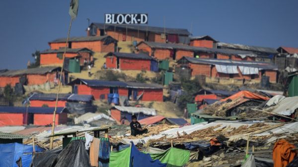 A Rohingya refugee child sits with drying wood for cooking on his roof at Thankhali refugee camp in Bangladesh's Ukhia district on Jan. 22, 2018 (Munir UZ ZAMAN / AFP)