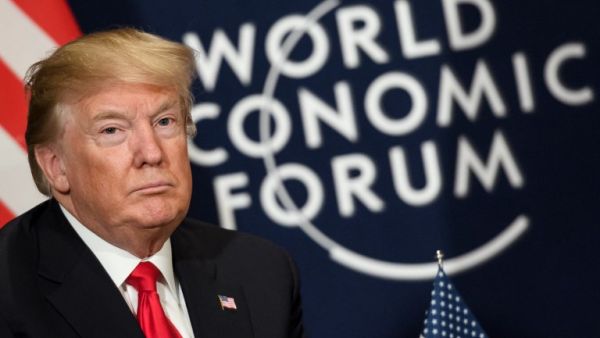 U.S. President Donald Trump looks on as he sits next to the logo of the World Economic Forum (WEF) annual meeting on January 26, 2018 in Davos, eastern Switzerland. 
(Fabrice COFFRINI / AFP)