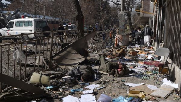 Afghan volunteers carry bodies at the scene of a car bomb exploded in front of the old Ministry of Interior building in Kabul on Jan. 27, 2018 (WAKIL KOHSAR / AFP)