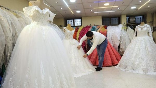 Man arranging dresses at a wedding dresses shop (AFP/File Photo)	 