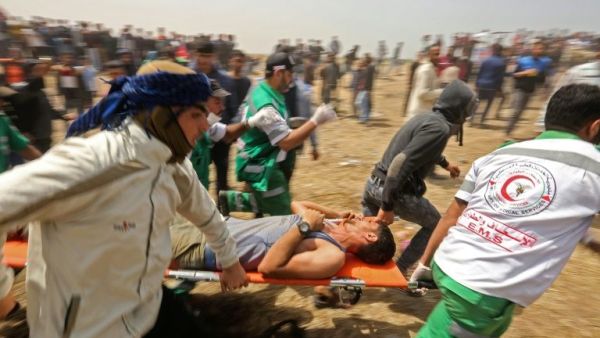 Palestinians evacuate an injured protester during clashes with Israeli security forces (AFP/File Photo)	