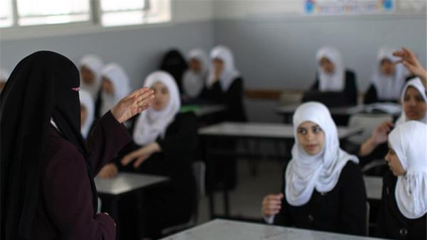 A Palestinian teacher instructs female students in a classroom in Gaza City on April 2, 201. (AFP/File)