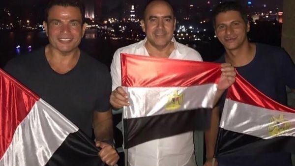 عمرو دياب ودينا الشربيني يلوحان بعلم مصر والأخيرة بقميص النوم