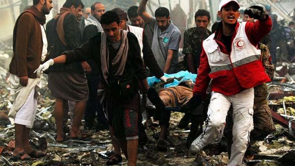 Yemeni rescue workers carry a victim on a stretcher amid the rubble of a destroyed building. (AFP/ File Photo)
