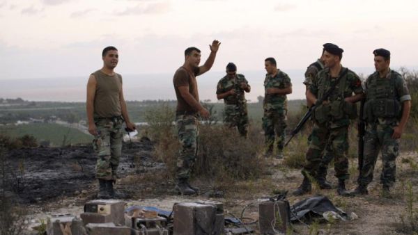Lebanese soldiers stand next to the remains of an Israeli spy device on September 5, 2014 near the village of Adloun in southern Lebanon. (AFP/Mahmoud Zayyat)