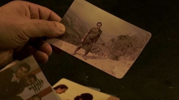 The Kataeb's former intelligence chief Assaad Chaftari looks through his wartime photos in a scene from Rugo and Weaver's doc "About a War." (Photos courtesy of Iterations Films)