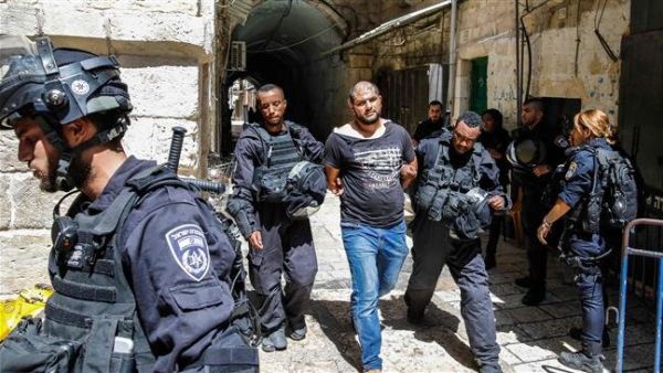 Members of Israeli security forces take into custody a Palestinian protester after clashes at the Aqsa Mosque compound on July 27, 2018. (AFP)