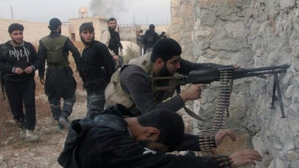 Syrian rebel fighters shoot through a hole in a wall towards forces loyal to the regime in Aleppo.(AFP / File)

