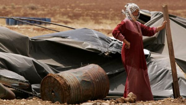 A Palestinian bedouin woman stands outside her demolished home. (AFP/File)