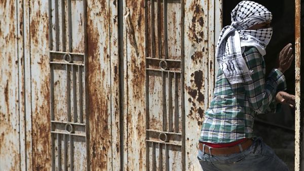 A Palestinian protester wearing the traditional chequerred keffiyeh (AFP)