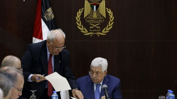 Palestinian president Mahmoud Abbas (R) speaks with Palestine Liberation Organization's Secretary General Saeb Erekat during a meeting of the Palestine Liberation Organization (PLO) (AFP)