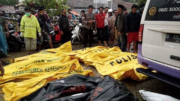Bodies of victims recovered along Carita beach are placed in body bags as families search for the missing on Sunday morning (AFP)