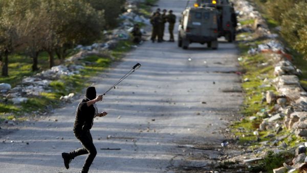 A Palestinian protester uses a sling to hurl stones towards Israeli troops (Twitter)