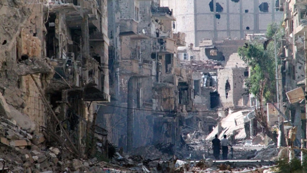 Two people walk through a destroyed neighborhood in Deir Ezzor. (AFP/Ahmad Aboud)