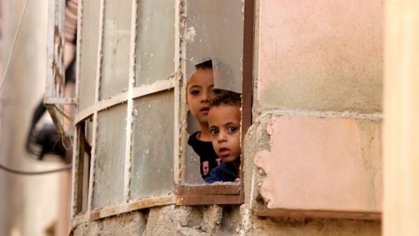 Palestinian children in al-Fawwar refugee camp watch the Israeli raids through their window. (AFP/File)