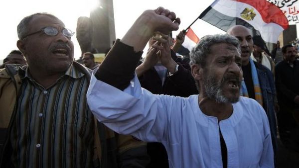 Egyptian anti-government protestors shout political slogans as they wave their national flag and banners during a march towards Cairo's landmark Tahrir. (AFP PHOTO/GIANLUIGI GUERCIA)