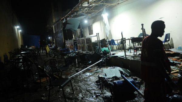 A man walks near the site of a car bomb explosion in Mogadishu on August 5, 2018. At least three were killed and five others injured after car bomb exploded outside a popular restaurant. (Mohamed ABDIWAHAB / AFP)