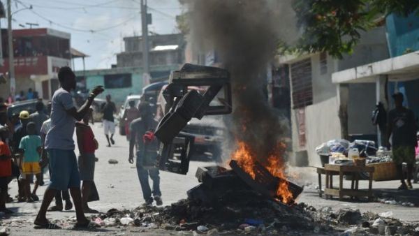 Demonstrator throws plastics onto a smouldering barricade in central Port-au-Prince, July 9, 2018, following two days of deadly looting and arson triggered by a quickly-aborted government attempt to raise fuel prices. (AFP/ File Photo)
