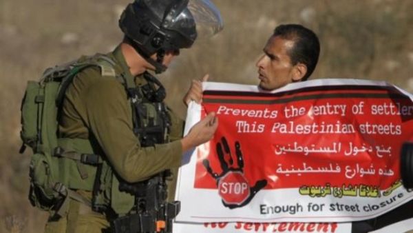 متظاهر فلسطيني في مواجهة مع جندي اسرائيلي. 