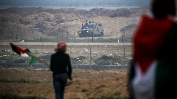 Gaza Strip east of Gaza City shows Palestinians protesting with Palestinian flags by the barbed-wire fence along the border with Israel, with an Israeli army vehicle seen across on the other side. (Said KHATIB / AFP)