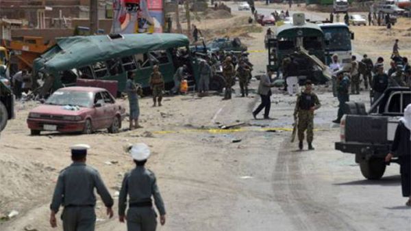 Afghan security personnel gather near the wreckage of buses which were carrying police cadets, at the site of a bomb attack on the outskirts of Kabul on June 30, 2016. (AFP)