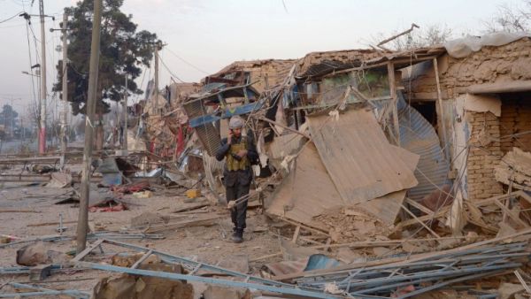 An Afghan security personnel walks along damaged buildings as he inspects the site of a bomb attack targeting the German consulate in Mazar-i-Sharif on November 11, 2016. (AFP/Farshad Usyan)