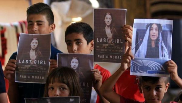 أطفال ايزيديون يحملون صور نادية مراد، التي فازت بجائزة نوبل للسلام