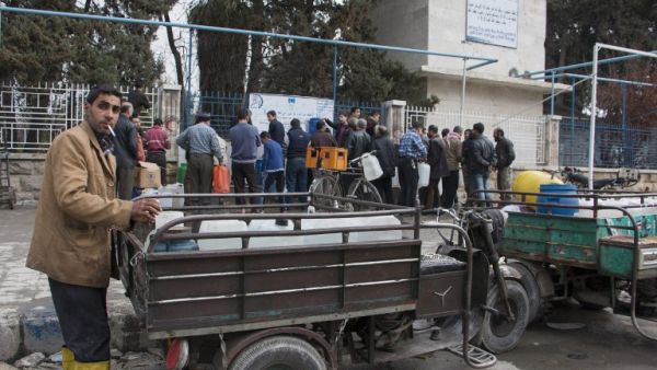 Aleppo residents line up outside to refill water cans as the ceasefire encourages people to be out in public. (AFP/Karam Al-Masri)