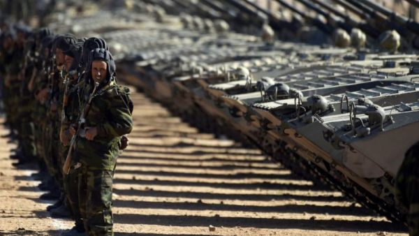 Algerian soldiers stand in front of a row of tanks. (AFP/File)