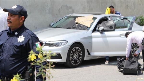 Police and forensic personnel work near the car in which Mexican radio and television journalist Juan Carlos Huerta was killed in Villahermosa, Mexico, on May 15, 2018. (AFP Photo)